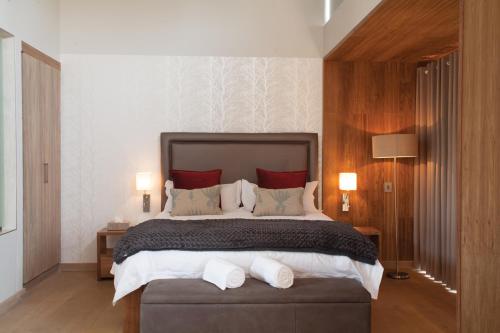 比勒陀利亚门林精品酒店的一间卧室配有一张带红色枕头的大床