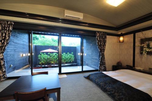 神户拉拉度假村（仅限成人入住）的一间卧室配有一张床、一张书桌和一个窗户。