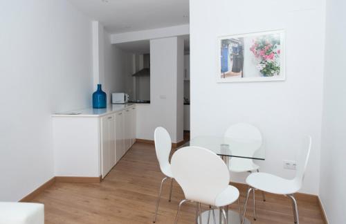 科尔多瓦Osario的白色的厨房配有白色的椅子和玻璃桌