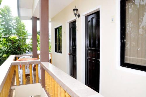 班塔延岛纳内特游客宾馆的阳台设有黑色的门和桌子。