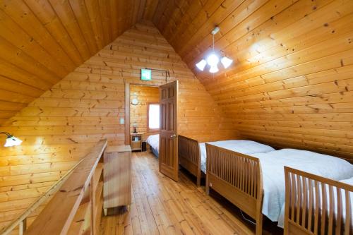小樽樱花园山林小屋的小木屋内一间卧室,配有两张床