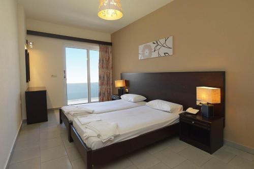 伊利索斯Ialysos City Hotel的一间卧室设有一张大床和大窗户