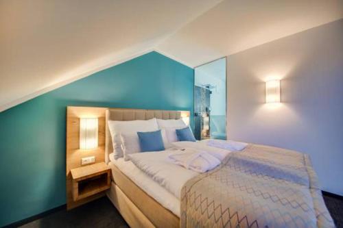 米特尔巴赫R&R Residenzen Aparthotel的一间卧室设有一张蓝色墙壁的大床