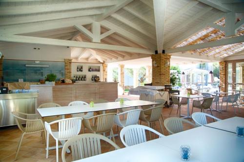 圣玛格利特迪普拉Eliantos Boutique Hotel & Spa的一间带桌椅的餐厅和一间厨房