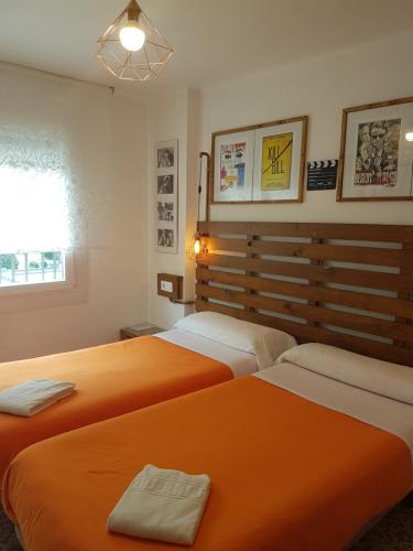 安道尔城巴里安蒂克旅馆&酒吧的配有橙色床单的客房内的两张床