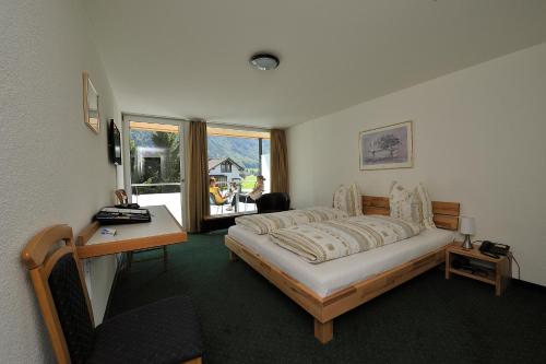 英格堡哈恩布里克酒店的一间卧室配有一张床、一张书桌和一个窗户。