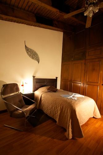 危地马拉康福特旅舍的一间卧室配有一张床和一把椅子