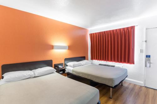 彭萨科拉Motel 6 - Pensacola West的酒店客房设有两张床和红色窗户。