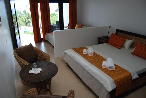 ArgaoPanorama de Argao Boutique Resort的卧室配有1张床、1张桌子和1把椅子