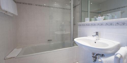 布伦瑞克Hotel Pfälzer Hof的白色的浴室设有水槽和淋浴。