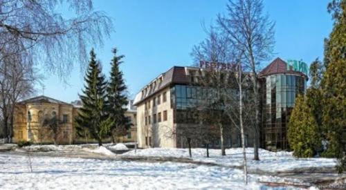 日托米尔盖伊基酒店的一座大建筑,在田野里,有雪和树木
