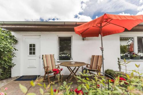 劳特尔巴赫Ferienwohnungen in ruhiger Ortsran的庭院配有桌椅和遮阳伞。