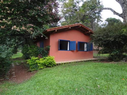 帕萨夸特鲁Chalés Del'Minas的院子内带蓝色窗户的小房子
