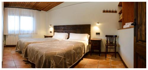 LlaviáEls Masos d'en Coll的一间卧室设有一张大床和一个窗户。