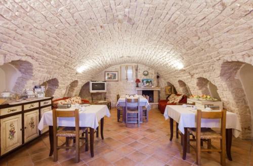 阿尔贝罗贝洛Agriturismo Masseria Casa Busciana的石头房里带桌椅的餐厅