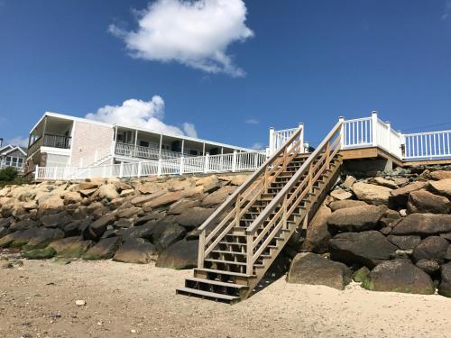 丹尼斯港花环汽车旅馆的通往岩石海滩上房屋的楼梯