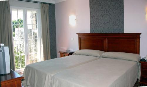 马贝拉唐阿尔弗雷多酒店的卧室设有一张白色大床和一扇窗户。