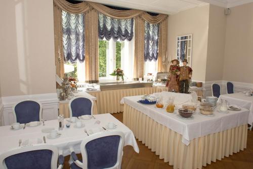 Schwebda斯洛斯沃尔夫斯布恩酒店的一间设有两张桌子和蓝椅的用餐室