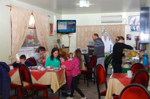 马拉圭Rioma Hotel的一群坐在餐厅桌子上的人
