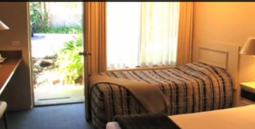 北克莱顿克莱顿莫纳什汽车旅馆&服务公寓的一间卧室设有一张床和一个滑动玻璃门