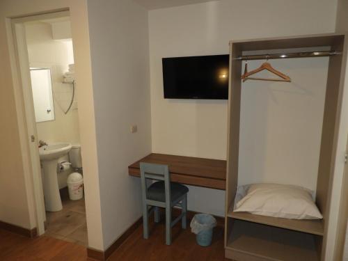 塔克纳Nice Inn Tacna的小房间设有一张桌子和一台墙上的电视
