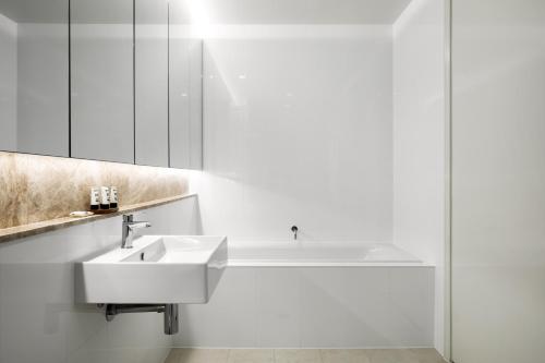 堪培拉堪培拉骑士桥公寓的白色的浴室设有水槽和浴缸。