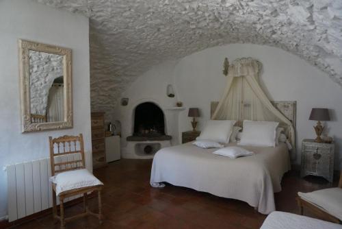 艾日维勒贝日里酒店的卧室配有白色的床和壁炉