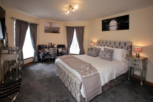 阿德西尔星星宾馆客房住宿加早餐旅馆的一间卧室配有一张床、一把椅子和窗户。