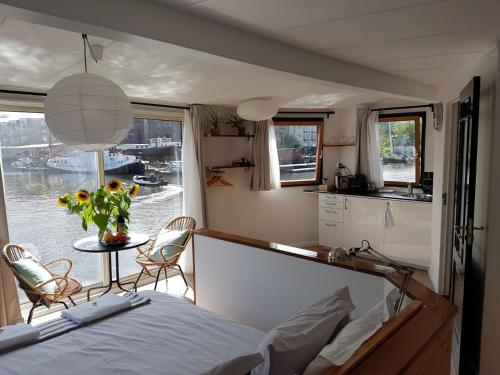 阿姆斯特丹迪亚船屋住宿加早餐旅馆的一间卧室配有一张床,厨房配有窗户