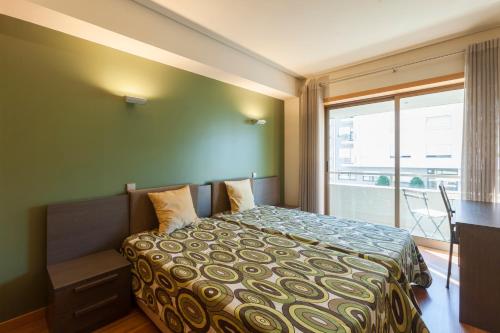 波尔图Onice Apartment的一间卧室配有一张床、一张书桌和一个窗户。