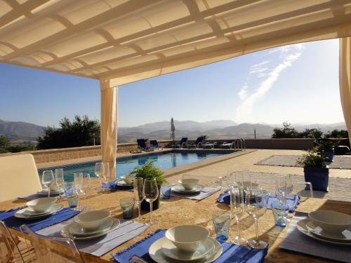 阿洛拉Casa Oasis的餐桌,带玻璃杯,享有游泳池的景色