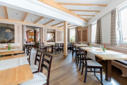 里格尔Gasthof - Hotel Kopf的配有木桌和椅子的餐厅