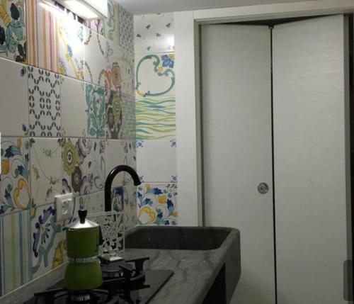 圣维托罗卡波Fresco Mare Blu的浴室设有水槽和彩色瓷砖墙面。