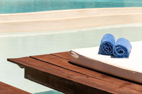 克里斯阿穆迪亚亚历山大黄金精品酒店（仅限成人）的游泳池旁的一张桌子和蓝色毛巾