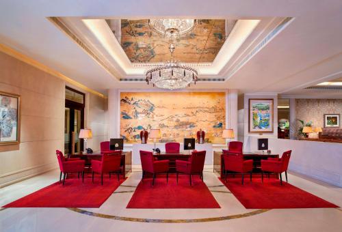 新加坡The St. Regis Singapore的一间用餐室,配有红色椅子和大画
