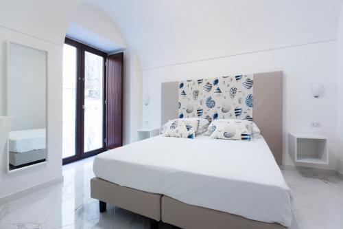索伦托Holiday Sorrento Center的白色的卧室设有一张大床和一个窗户