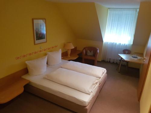 利特曾多夫Gasthof Krapp的一间卧室配有一张床、一张桌子和一个窗户。