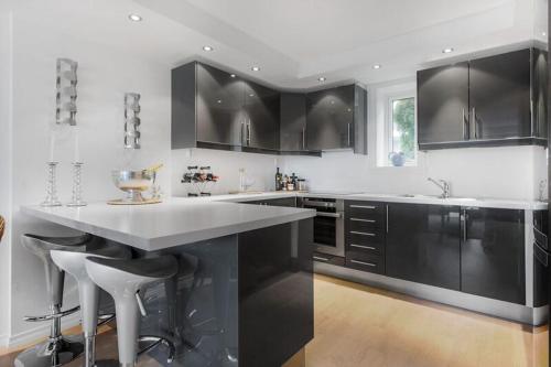 卑尔根Øyjorden Apartment的厨房配有黑色橱柜和白色台面
