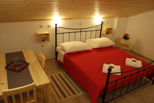 Novaki MotovunskiGuesthouse Casetta Verde的一间卧室配有红色的床、一张桌子和糕点