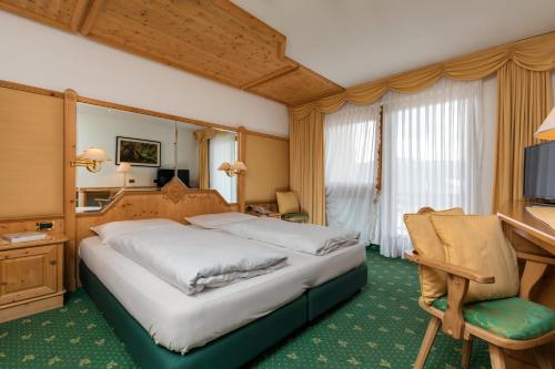 科尔福索Garni Criss的酒店客房设有一张大床和一张书桌。