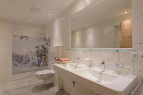 洛伊塔施汉德尔公寓酒店的浴室设有2个水槽、卫生间和镜子。