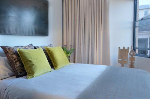 悉尼KC伊丽莎白湾公寓的一间卧室配有一张带黄色枕头的大床