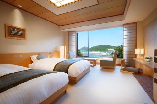鸟羽图巴潮路国际酒店的酒店客房设有两张床和大窗户。