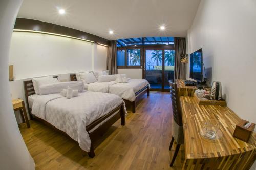跋麒班塔勒腾轮酒店的酒店客房设有两张床和电视。