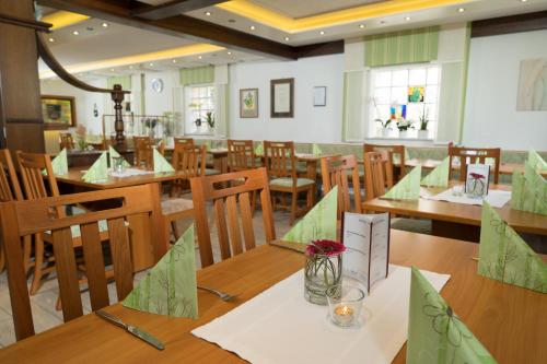 Hammelburg- Obererthal苏姆斯特恩乡村旅馆的用餐室配有木桌和椅子