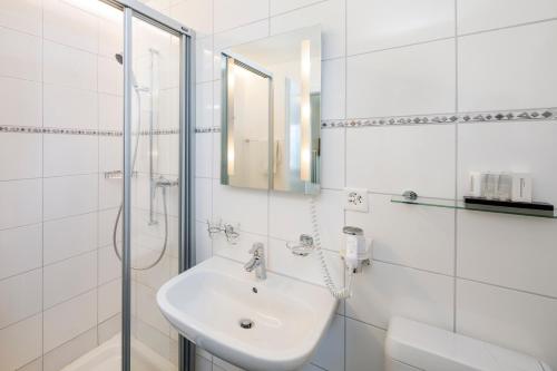 卢塞恩桑弄伯格酒店的白色的浴室设有水槽和淋浴。