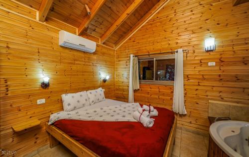 Beẕet山海木屋的小木屋内一间卧室,配有一张床