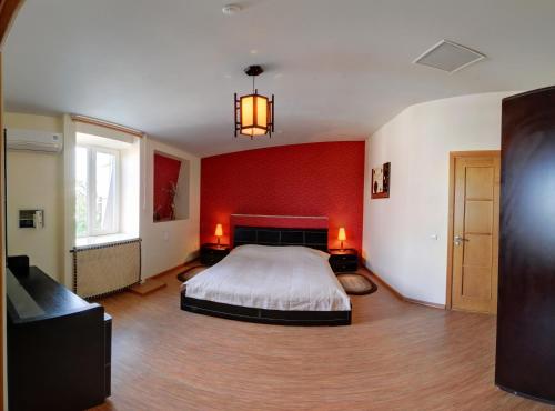 赫梅利尼茨基兴特拉尔尼酒店的一间卧室设有一张床和红色的墙壁