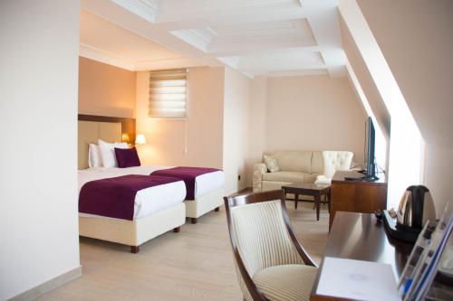 贝尔格莱德Xenon Hotel & SPA的配有一张床和一把椅子的酒店客房