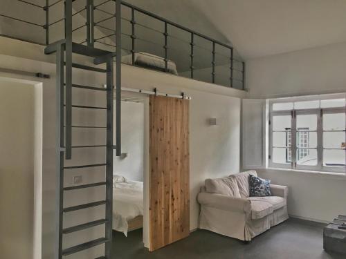 英雄港Casa do Pisão - Cosy and Modern Two-Bedroom Townhouse的一张高架床,在房间中设有梯子